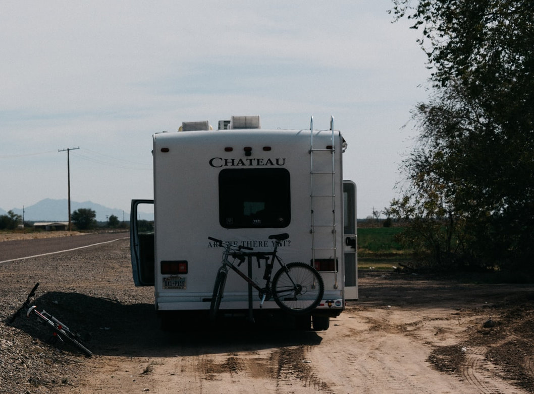 white RV with attached bikes parked on the shoulder