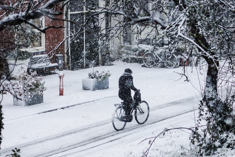 woman riding bicycle on snowy street