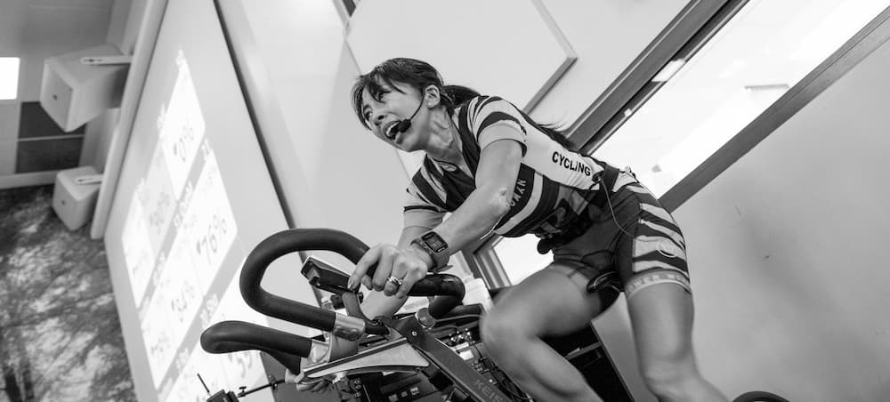 female traine coaching spin class