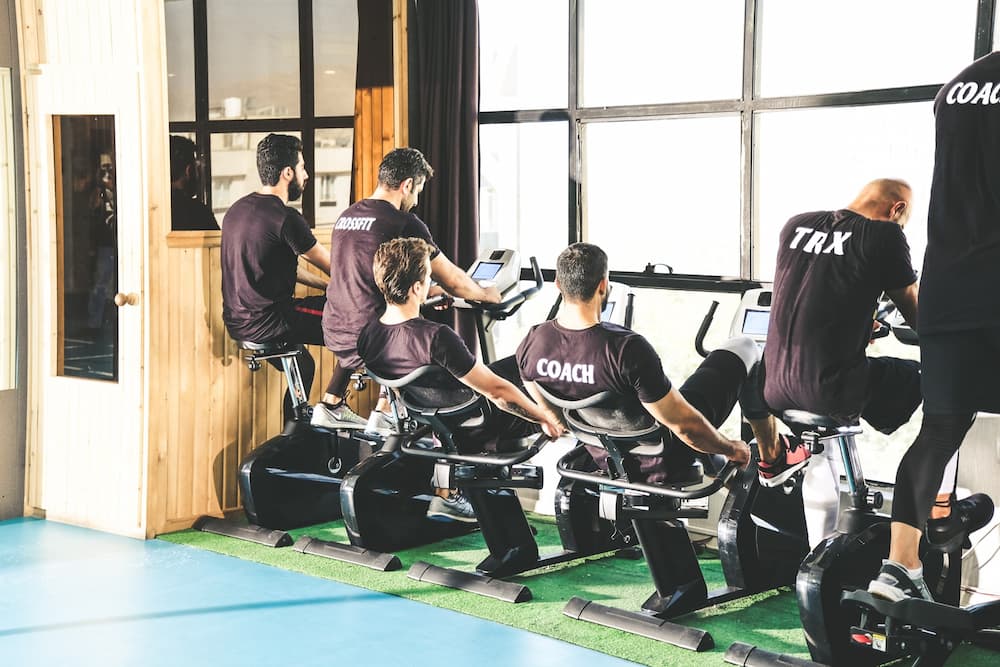 several young men riding on different bike trainers in gym