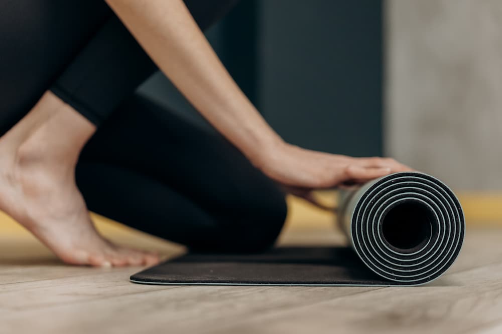 female cyclist unrolling the best bike trainer mat