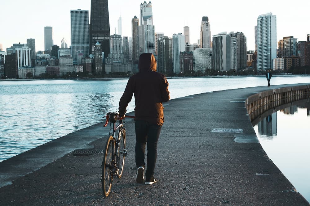 male cyclist pushing his bike in Chicago Illinois