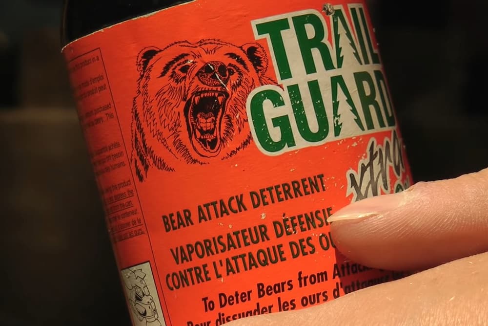 male cyclist holding bear spray canister