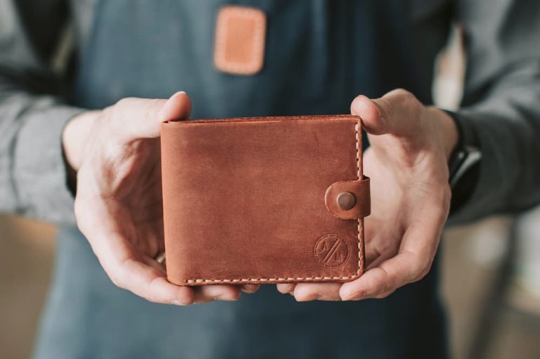 male cyclist holding brown leather wallet