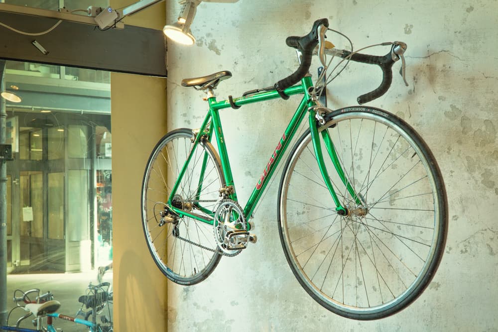 green bicycle hanging on the wall