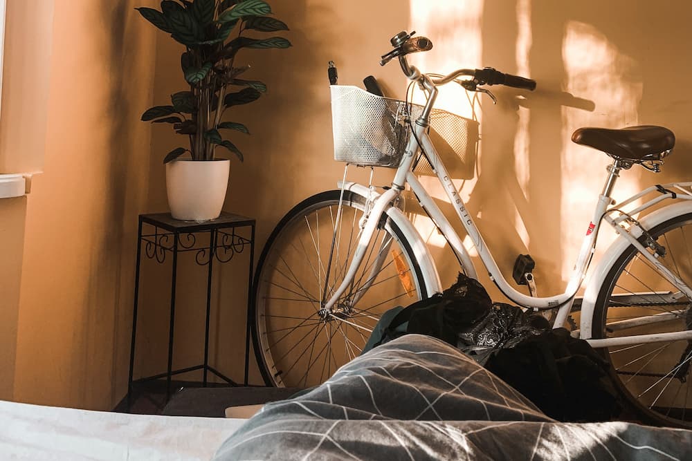 bicycle put against the wall in apartment bedroom